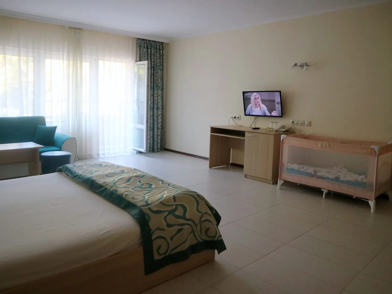 Family Room: double bed, desk with TV and the balcony door