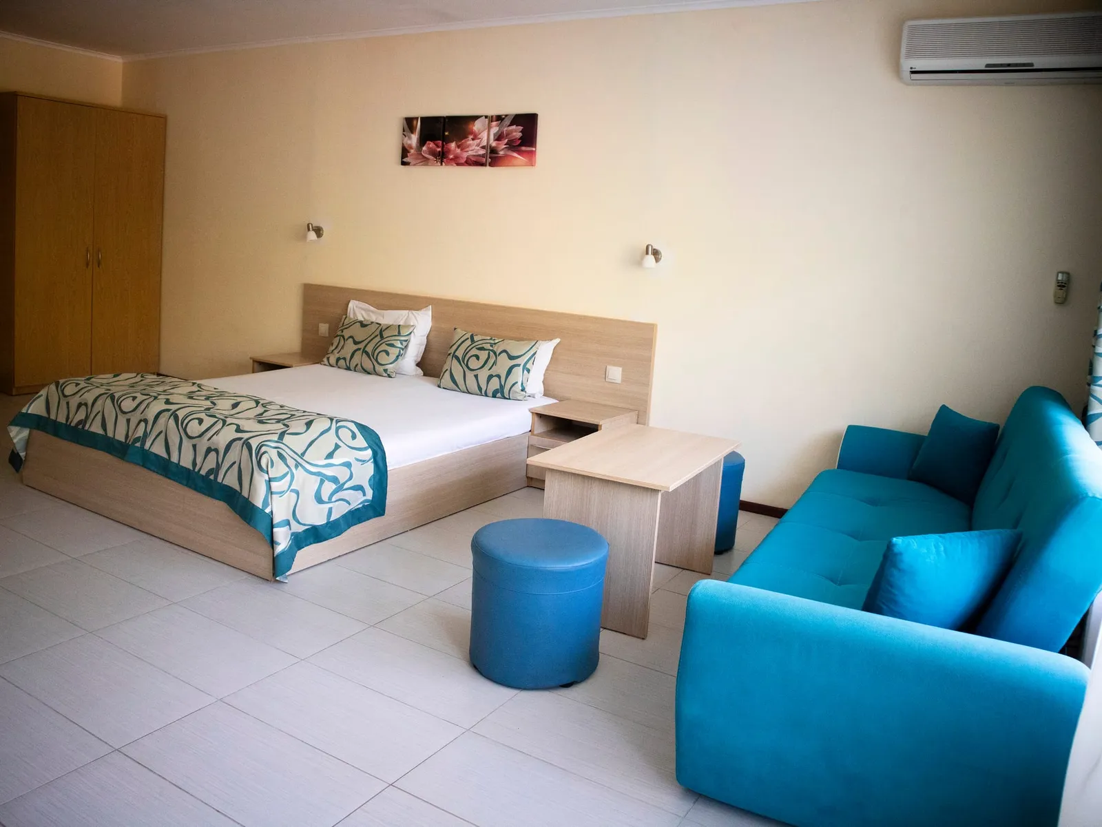Family Room: double bed, turquoise sofa and poufs