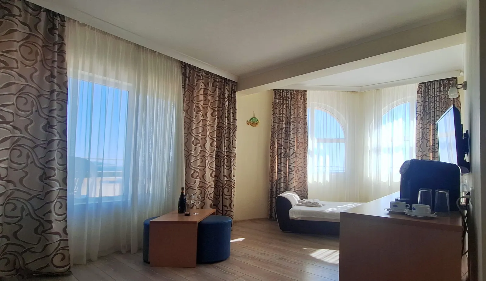Panorama-Studio: Studio mit Bett, Sofa und Fernseher an den Rundbogenfenstern
