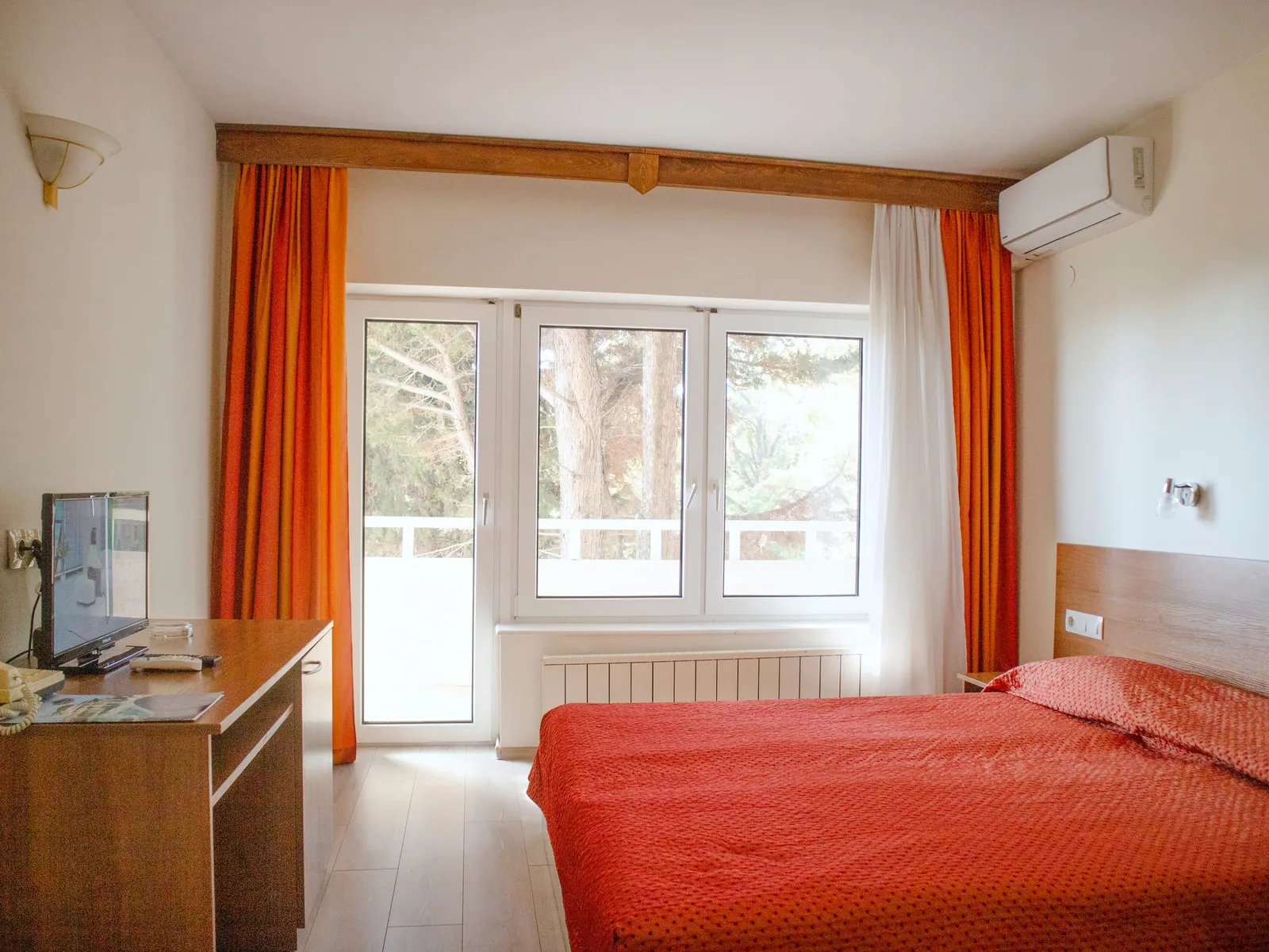 Einzelzimmer: Bett und Fenster zum Balkon
