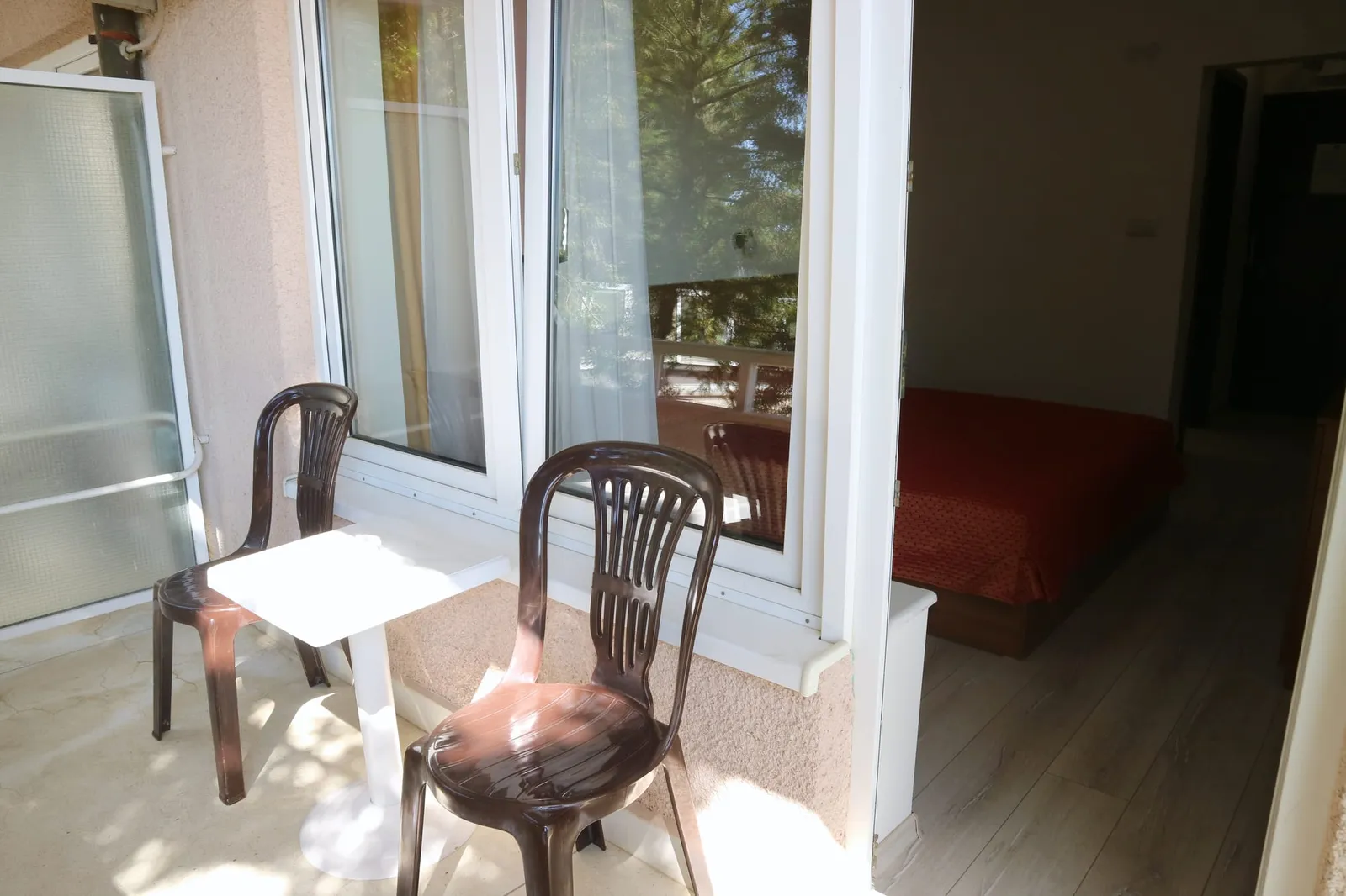Einzelzimmer: Balkon mit Tisch und zwei Stühlen