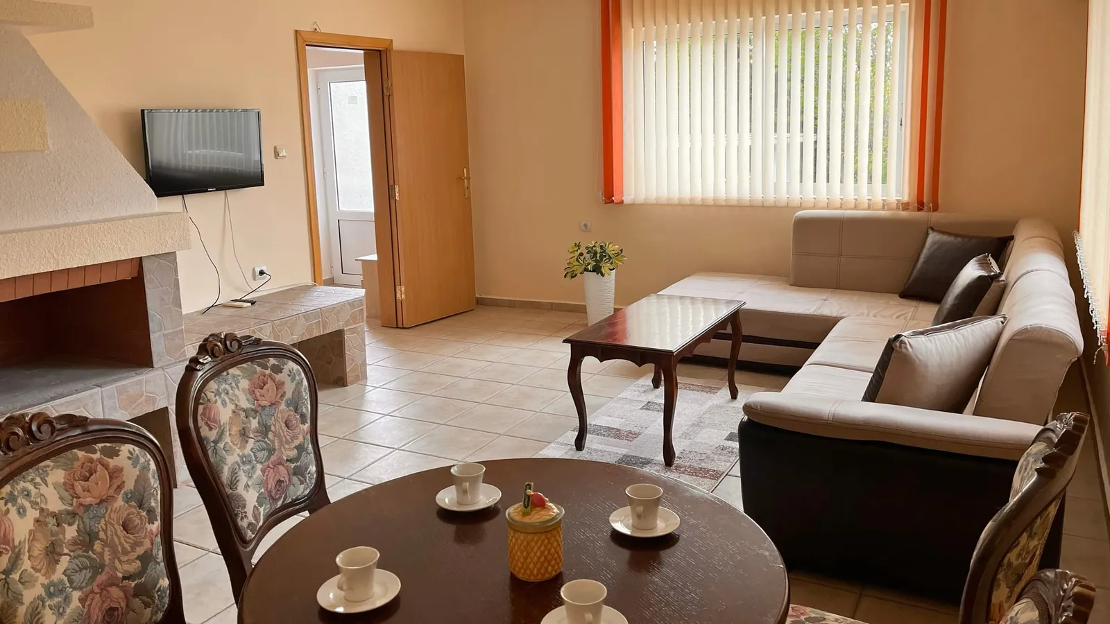 Villa: living room with a corner sofa, dining table and fireplace
